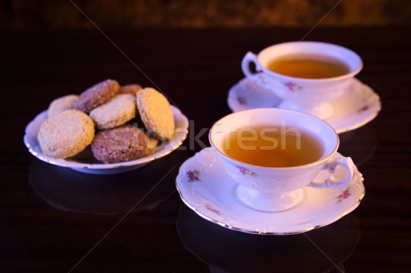 Old-style kettle with two cups of tea with cookies on black Stock photo © dla4