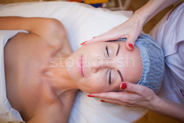 Cosmetology doctor makes woman treatments facial massage Stock photo © dmitriisimakov