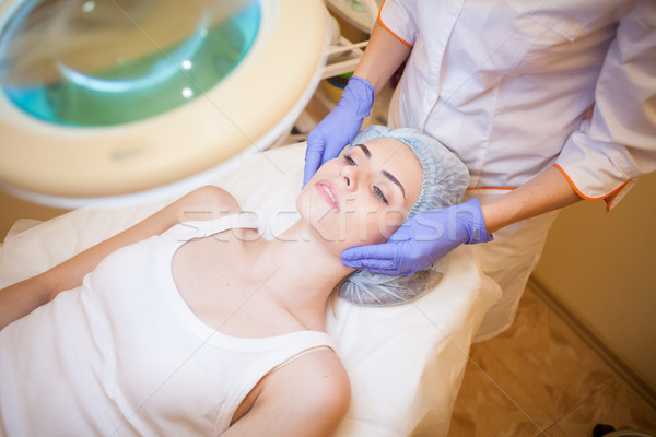 Cosmetology doctor makes woman treatments facial massage Stock photo © dmitriisimakov