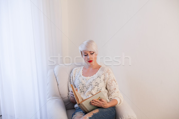 woman reading a book in a Chair in a white room Stock photo © dmitriisimakov