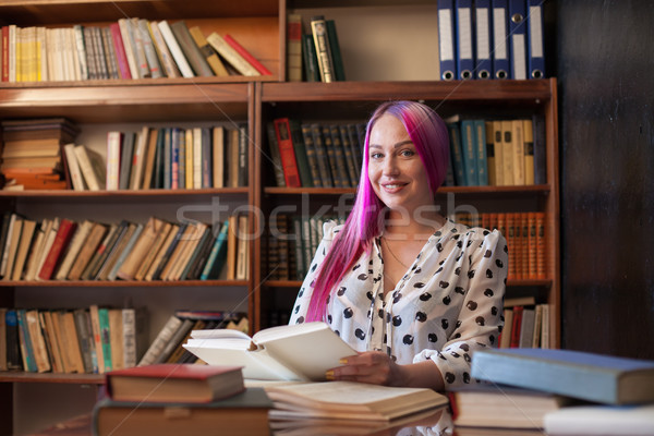 woman with pink hair reads books in the library Stock photo © dmitriisimakov