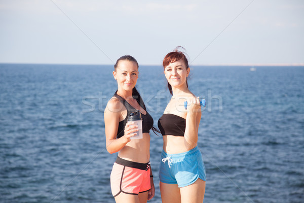 fitness girls with shaker and dumbbells on the beach Stock photo © dmitriisimakov