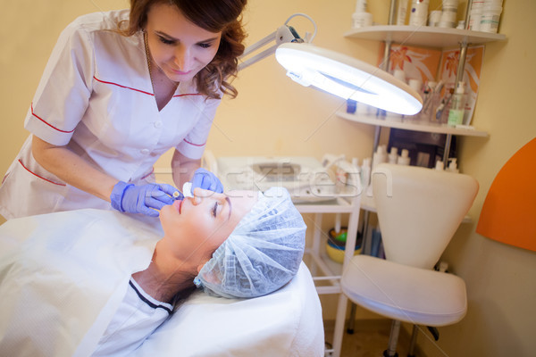 Stock photo: doctor beautician increases lip patient an injection syringe Spa