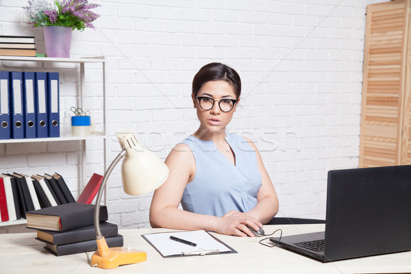 Business Girl Sits In A White Office Works At The Computer Stock