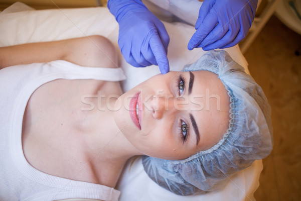 doctor cosmetologist shows on face patient Spa Stock photo © dmitriisimakov