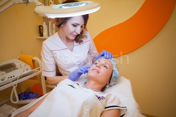 doctor cosmetolog shows a woman problem on face Stock photo © dmitriisimakov