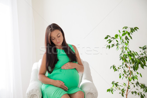 a pregnant woman before childbirth sits in white couch Stock photo © dmitriisimakov