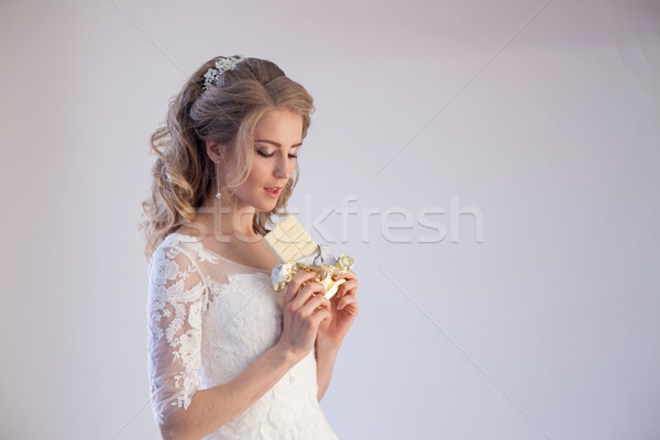 Stock photo: bride in wedding dress holding a chocolate