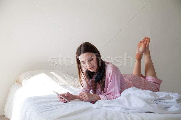 Lány rózsaszín pizsama ágy zene fejhallgató Stock fotó © dmitriisimakov