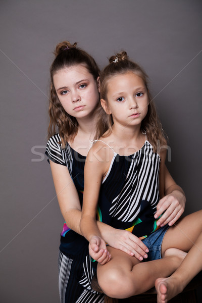 Stock photo: two sisters girls portrait on a grey background