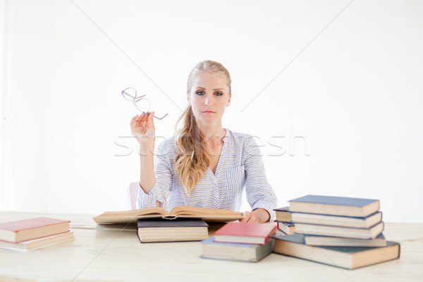 female teacher sitting at a table of many books Office Stock photo © dmitriisimakov