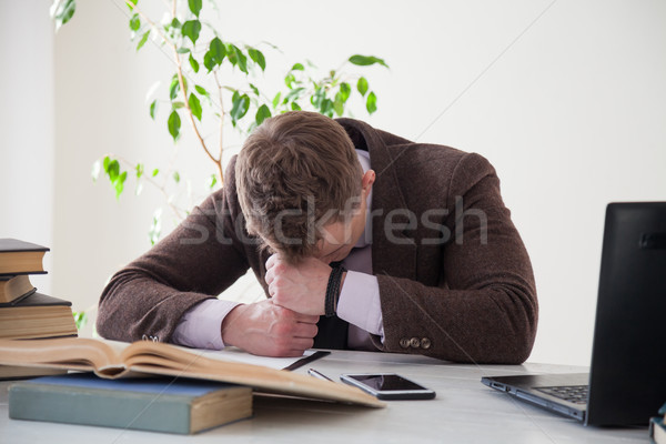 A Man In A Business Suit Fell Asleep At A Desk Stock Photo
