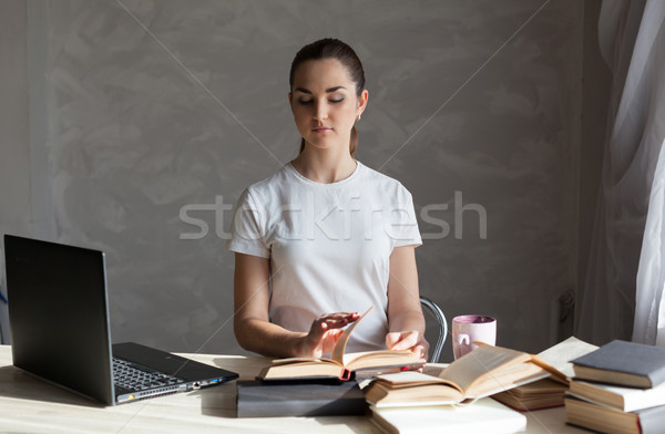 girl is preparing for the exam reading book works at the computer Stock photo © dmitriisimakov
