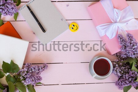 on the white table lilac, gift, notebook, cup of tea Stock photo © dmitriisimakov