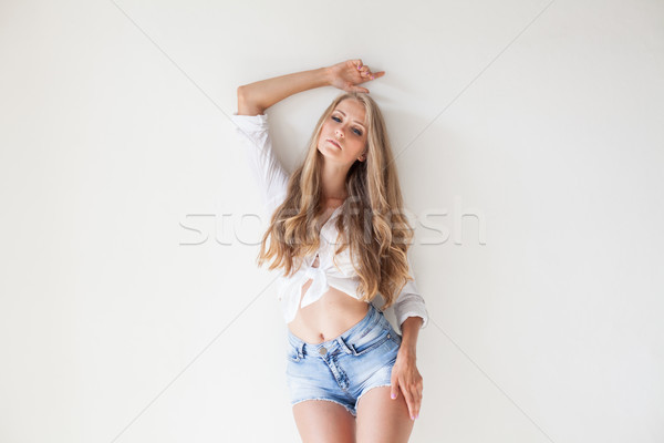 blonde girl with blue eyes in shorts on a white background Stock photo © dmitriisimakov