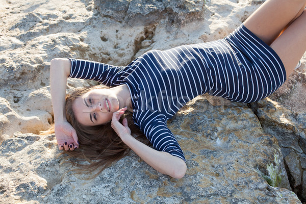 Ragazza bugie indietro pietra spiaggia strisce Foto d'archivio © dmitriisimakov