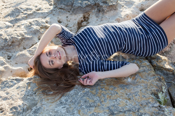 Ragazza bugie indietro pietra spiaggia strisce Foto d'archivio © dmitriisimakov