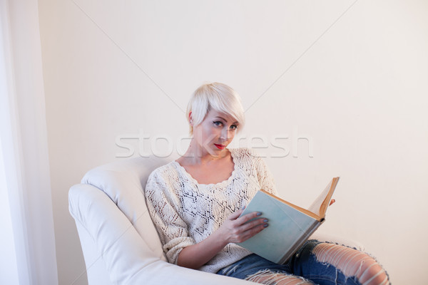 woman reading a book in a Chair in a white room Stock photo © dmitriisimakov