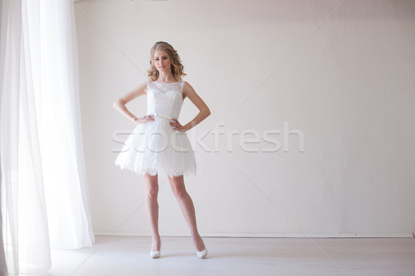 Stock photo: girl in a wedding dress stands in a white room wedding