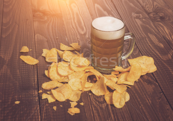 Frothy beer and chips Stock photo © dmitroza