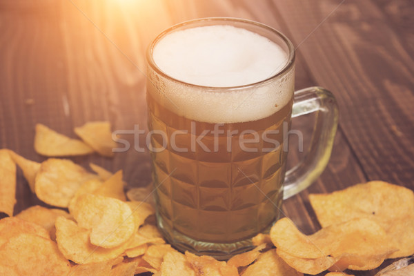 Frothy beer and crunchy chips Stock photo © dmitroza