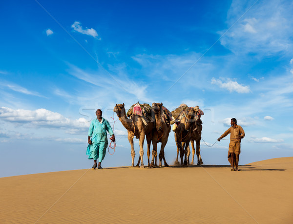 Two cameleers (camel drivers) with camels in dunes of Thar deser Stock photo © dmitry_rukhlenko