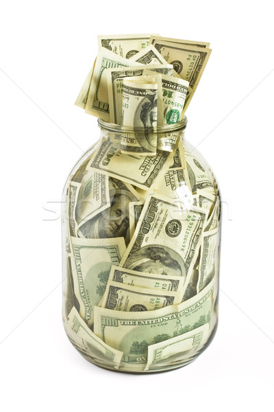 Stock photo: Hundreds of dollars stuffed in a glass jar