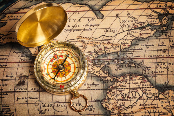 Stock photo: Old vintage golden compass on ancient map