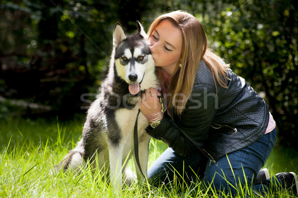 Girl is sitting with her dog in the grass Stock photo © DNF-Style
