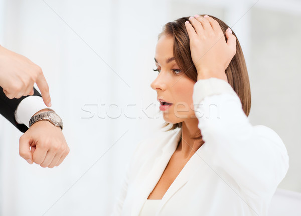 boss showing time to stressed businesswoman Stock photo © dolgachov