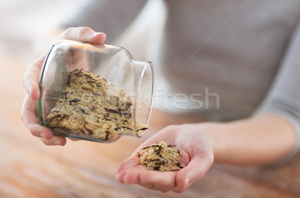 female emptying jar with white and wild black rice Stock photo © dolgachov