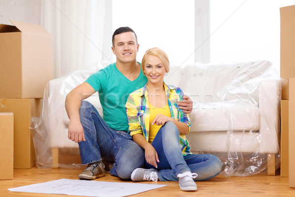 smiling couple looking at bluepring in new home Stock photo © dolgachov