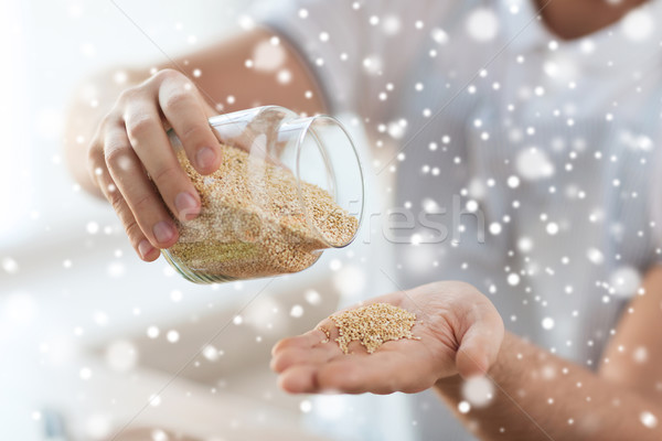 close up of male emptying jar with quinoa Stock photo © dolgachov