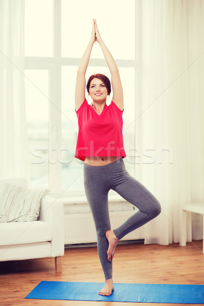 smiling redhead teenager meditating at home Stock photo © dolgachov