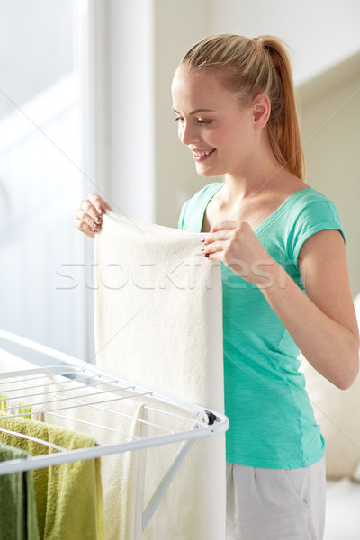 Stock photo: happy woman hanging clothes on dryer at home