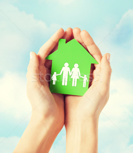 hands holding green house with family Stock photo © dolgachov