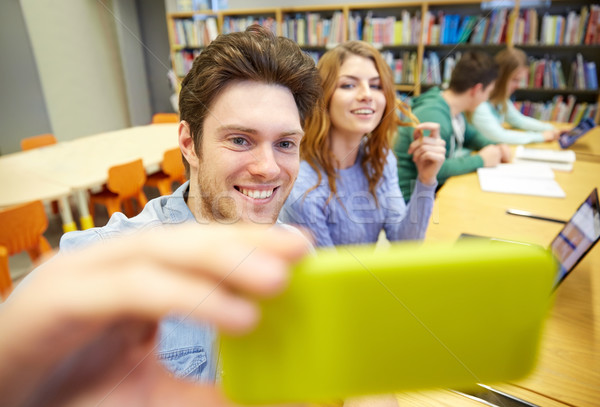 Stock photo: students with smartphone taking selfie in library