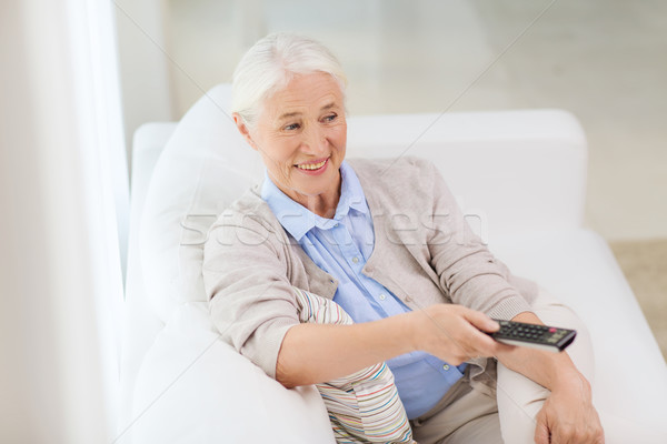 happy senior woman watching tv at home Stock photo © dolgachov