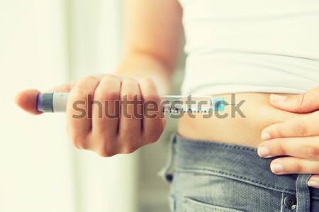 man with syringe making insulin injection Stock photo © dolgachov