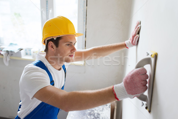 smiling builder with grinding tool indoors Stock photo © dolgachov