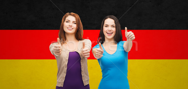 smiling girls showing thumbs up over german flag Stock photo © dolgachov