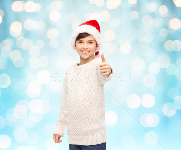 smiling happy boy in santa hat showing thumbs up Stock photo © dolgachov