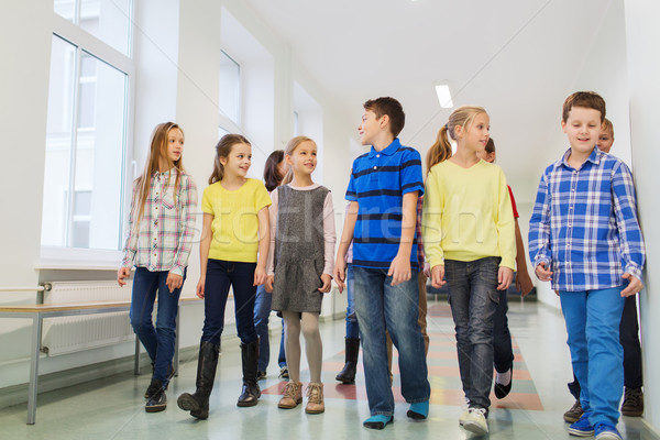 group of smiling school kids walking in corridor Stock photo © dolgachov