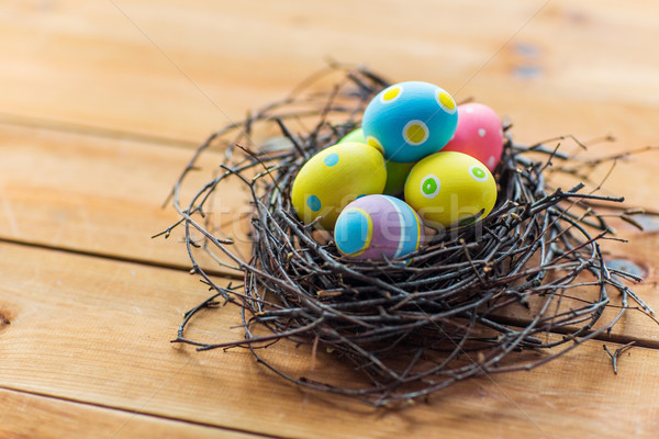 close up of colored easter eggs in nest on wood Stock photo © dolgachov