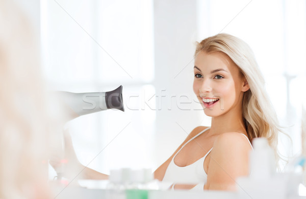happy young woman with fan drying hair at bathroom Stock photo © dolgachov