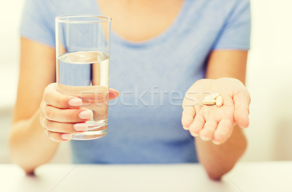 close up of woman hands with pills and water Stock photo © dolgachov