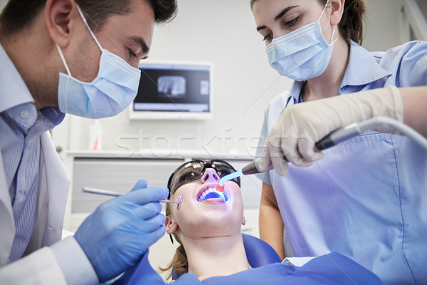 dentists treating woman patient teeth at clinic Stock photo © dolgachov