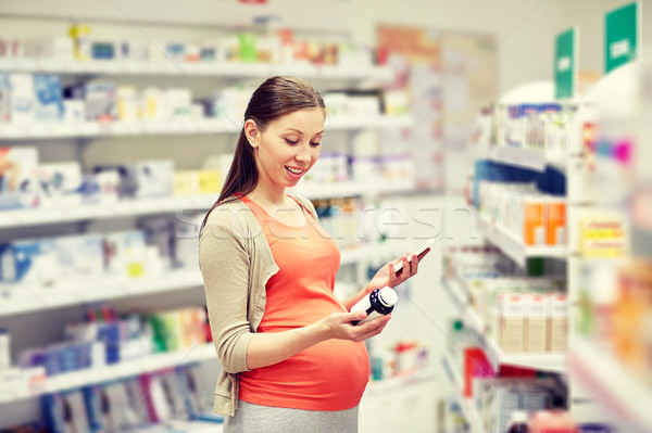 happy pregnant woman with smartphone at pharmacy Stock photo © dolgachov