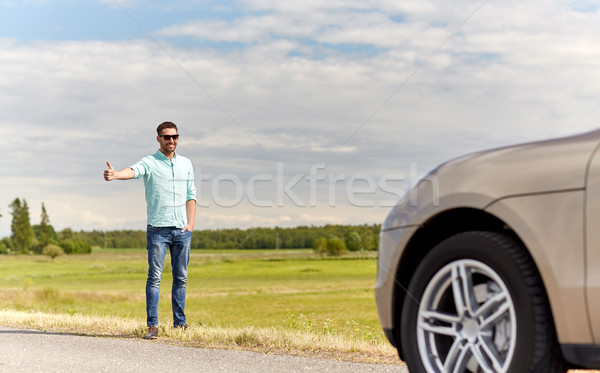 man hitchhiking and stopping car at countryside Stock photo © dolgachov