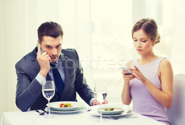 Ocupat cuplu smartphone-uri restaurant tehnologie vacanţă Imagine de stoc © dolgachov